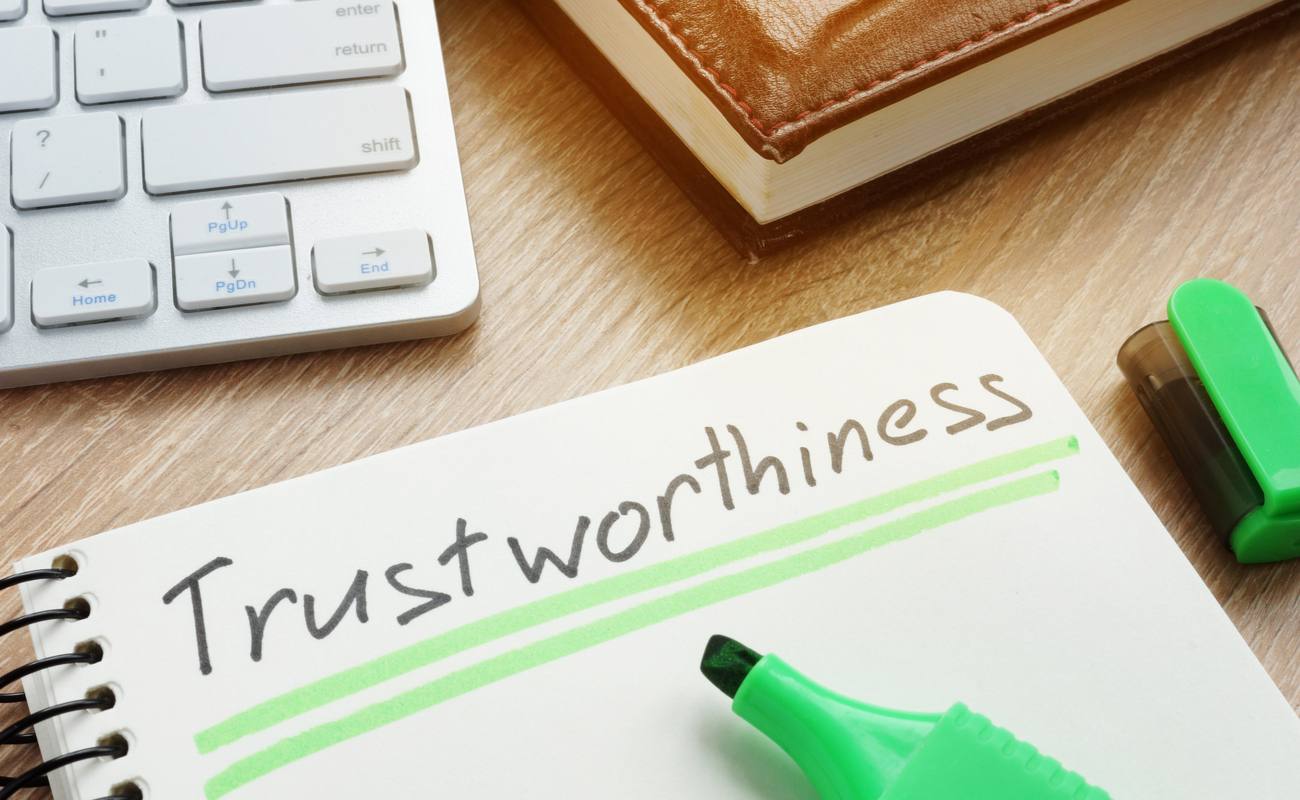Trustworthiness written in a notepad with green lines underneath it