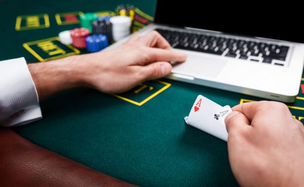 Person playing online and live poker with 2 ace cards