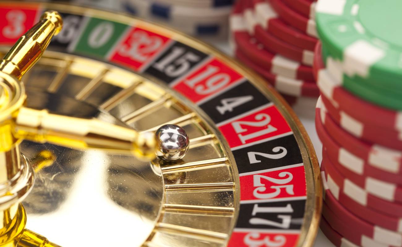 Close-up of beautiful gold roulette with chips on a white background.