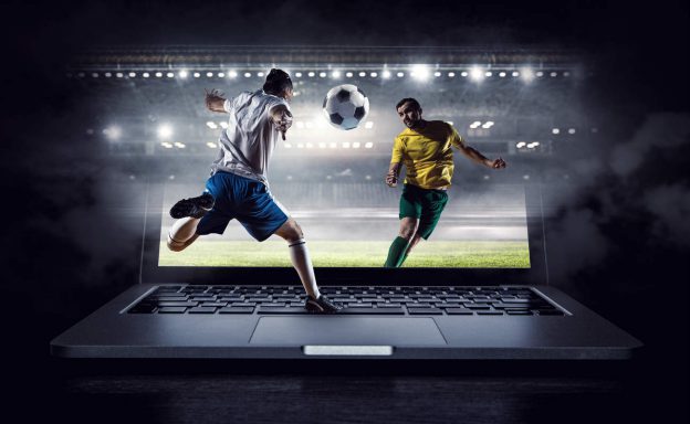 Footballers playing football on a laptop in a stadium