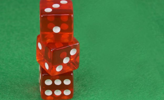 Three red dices on green cloth