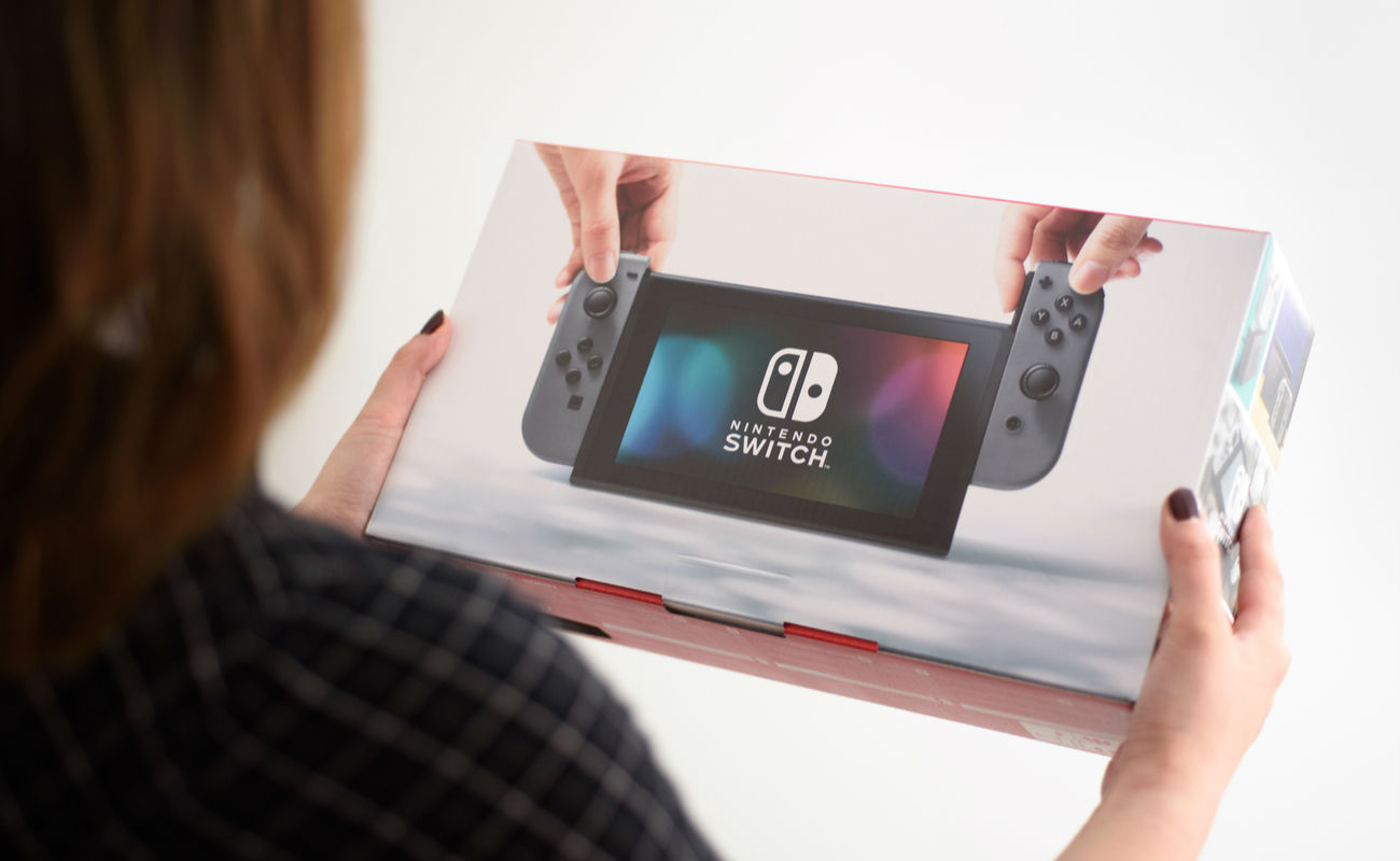 A woman holding a brand new Nintendo Switch console