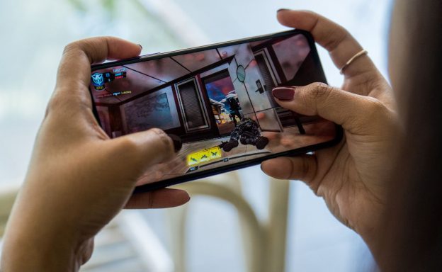 Women hands doing online gaming on her mobile